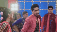 a man and a woman are dancing together in a room while a group of people are standing around them .