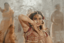 a woman in a red and gold blouse is dancing
