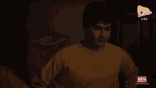 a man in a yellow shirt is standing in front of a screen that says live