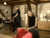 a woman sits on a red chair in a living room with the number 4 above her