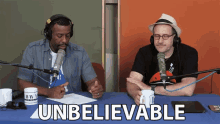 two men sitting at a table with the word unbelievable written on the table