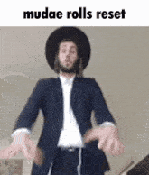 a man in a suit and hat is making a funny face .