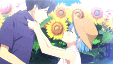 a man and a woman are standing in front of sunflowers