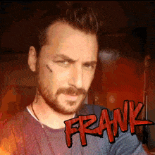 a man with a beard and a tattoo on his face has the word frank on his chest