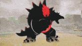 a black monster with red spikes is standing on top of a sandy field .