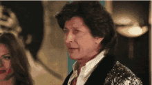 a woman in a sequined jacket stands next to a man in a black jacket