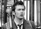 a man in a suit and tie is holding a gas mask in his hand .