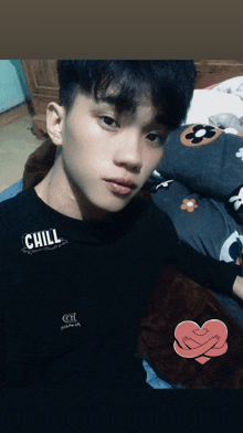 a young man is wearing a black shirt that says chill on the front