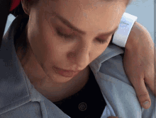 a close up of a woman 's face with a button on her shirt