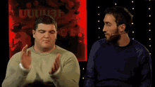 two men are sitting next to each other and one of them is saying bravo bro