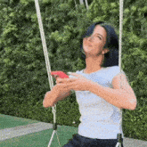 a woman is sitting on a swing holding a phone