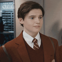 a young man is wearing a suit and tie with the words son of a griffin behind him