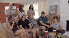 a group of people sitting on a couch with a sign that says home sweet home