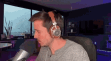 a man wearing headphones is sitting in front of a microphone in a room
