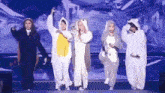 a group of women are standing next to each other on a stage .