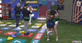 a group of people playing a game with a sign that says let 's eat in the background