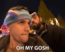 a man wearing a headband with bunny ears says " oh my gosh "