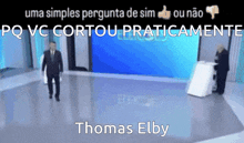 a man in a suit and tie is standing in front of a podium with the name thomas elby written on the bottom