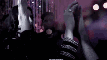 a woman in a black dress is dancing with a man in a dark room .