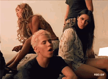 a group of people sitting on a bed with a rbd.gif watermark