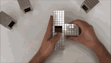 a person is holding a silver cube that looks like a maze