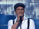 a man singing into a microphone with the number 13 on the screen