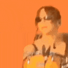 a woman wearing sunglasses and headphones is playing drums on a stage .