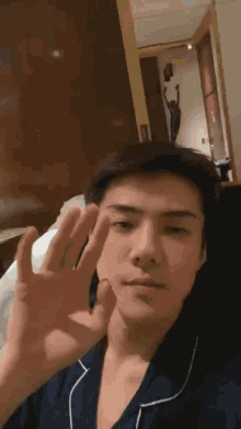 a young man is making a peace sign with his finger