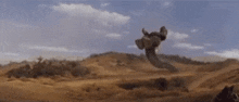 a snake is flying through the air in a desert .