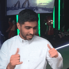 a man in a white shirt giving a thumbs up sign