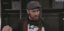 a man with a beard and a hat is standing in a locker room .
