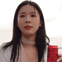 a woman is holding a red can that says ' ginger ale ' on it