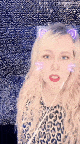 a woman wearing headphones and a leopard print shirt has a cat ear sticker on her head