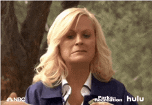 a woman is wearing a blue jacket that says parks recreation on it
