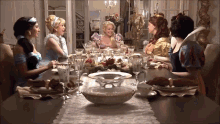 a group of princesses are sitting around a table with plates and glasses