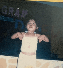 a young girl stands in front of a sign that says cram welcomes