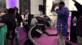 a man in a blue shirt is dancing in front of a crowd in a church