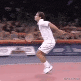 a tennis player is jumping in the air while holding a tennis racket