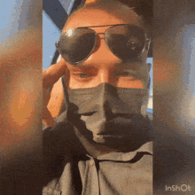a man wearing sunglasses and a face mask is sitting in a car ..