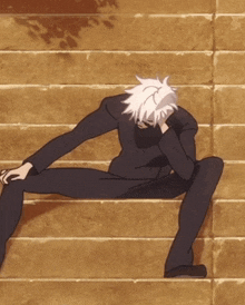 a man with white hair is sitting on a set of stairs with his legs crossed
