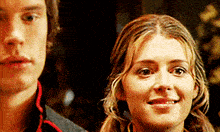 a man and a woman are standing next to each other and smiling for the camera