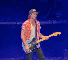 a man playing a guitar and singing into a microphone