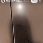 a blurred image of a cell phone with a follow button in the corner