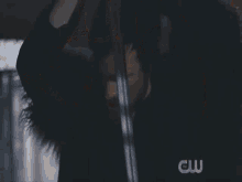 a man is standing in front of a painting with the cw logo on the bottom