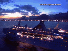 a large cruise ship is in the water at night with mountains in the background and the words estamos apresentando above it
