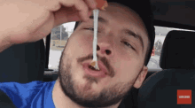 a man with a beard is eating a piece of cheese with a subscribe button on the bottom right