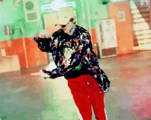 a man wearing a hat and a floral jacket is dancing