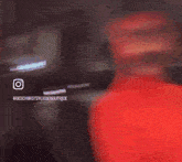 a blurry picture of a person standing in a room with a pink light