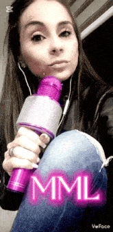 a woman is holding a purple microphone with the word mml on it