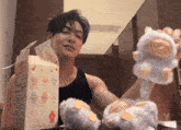 a man is holding a stuffed animal in front of a box that says " rabbit " on it
